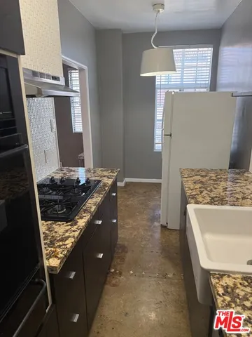 a kitchen with sink stove and cabinets