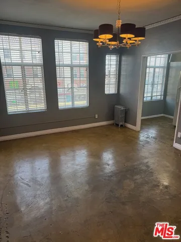 an empty room with windows and ceiling fan