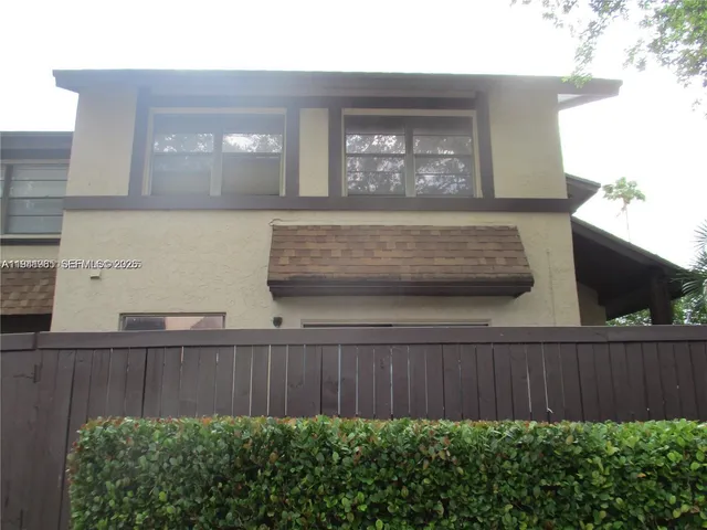 a view of backyard with potted plants and wooden fence