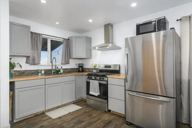a kitchen with stainless steel appliances a refrigerator sink and cabinets