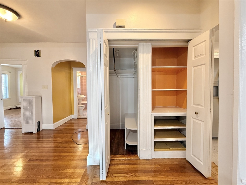 49 Favre Street, Unit 2 Boston, MA 02126 - Photo 14 of 22 a view of empty room with a fireplace and wooden floor