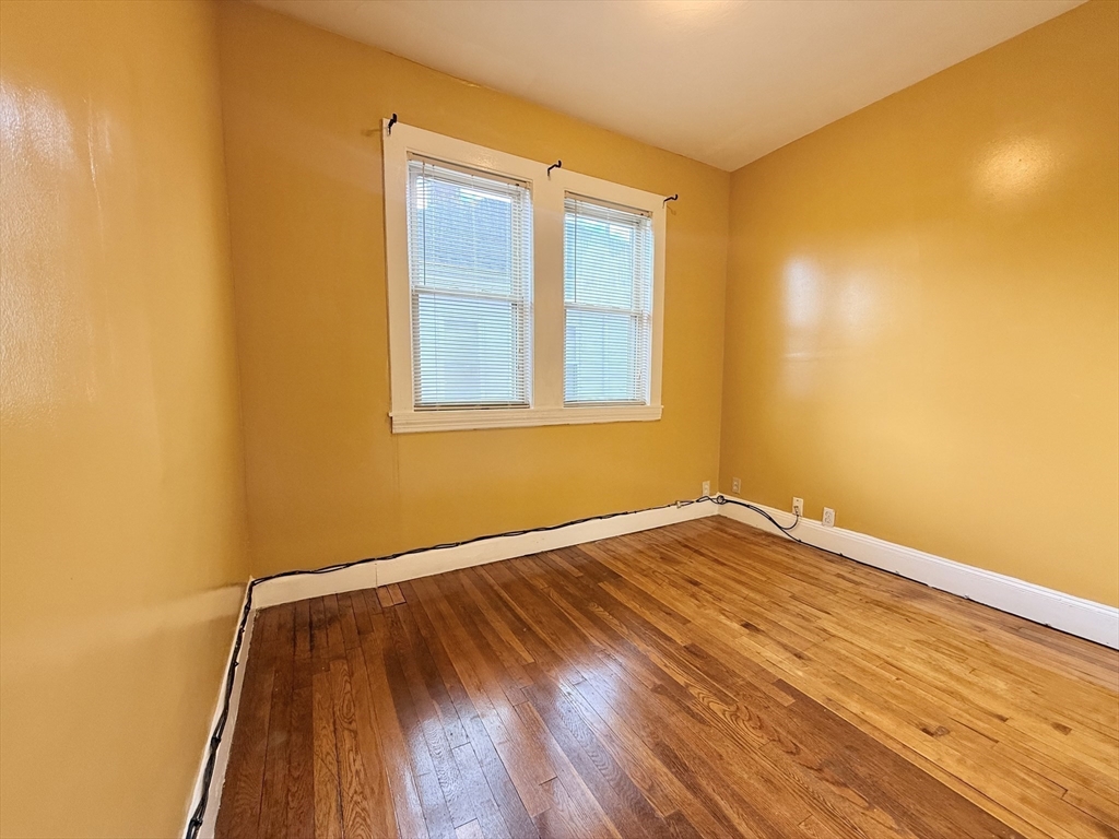 49 Favre Street, Unit 2 Boston, MA 02126 - Photo 18 of 22 a view of an empty room with wooden floor and a window
