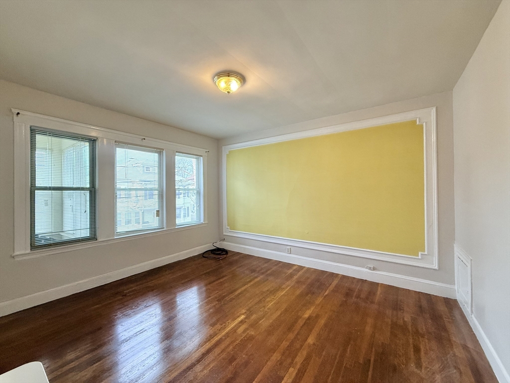 49 Favre Street, Unit 2 Boston, MA 02126 - Photo 7 of 22 a view of an empty room with wooden floor and a window