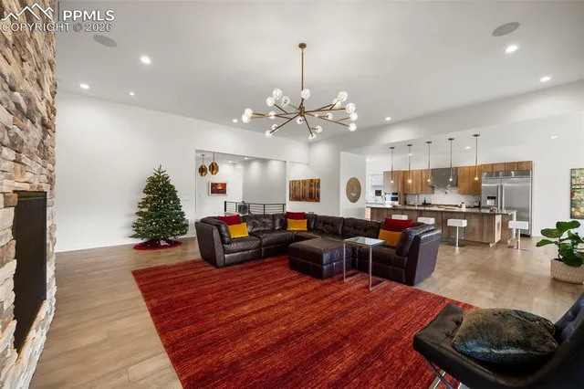 a living room with furniture kitchen view and a chandelier