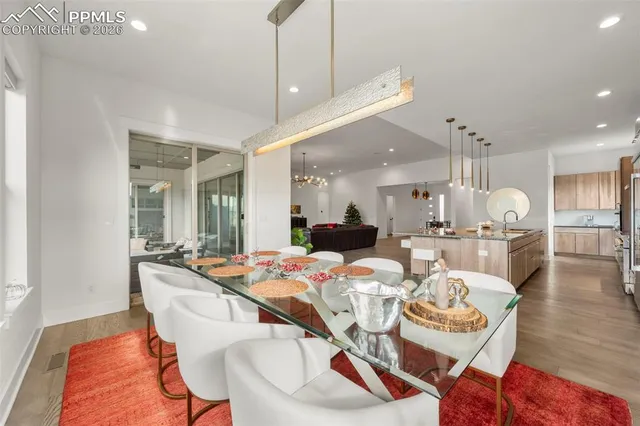 a dining room with furniture a kitchen view and wooden floor