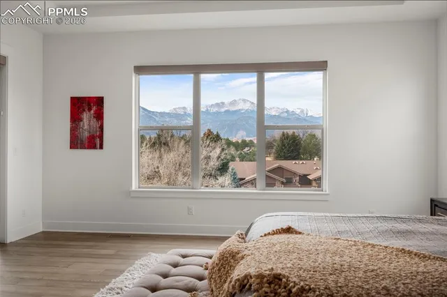 a bedroom with a bed and a window with chair