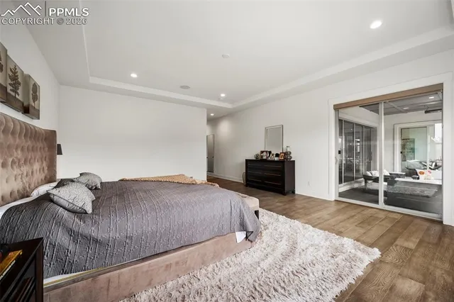 a spacious bedroom with a bed and wooden floor