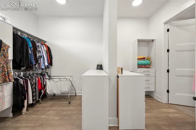 a view of walk in closet with clothes and shoes