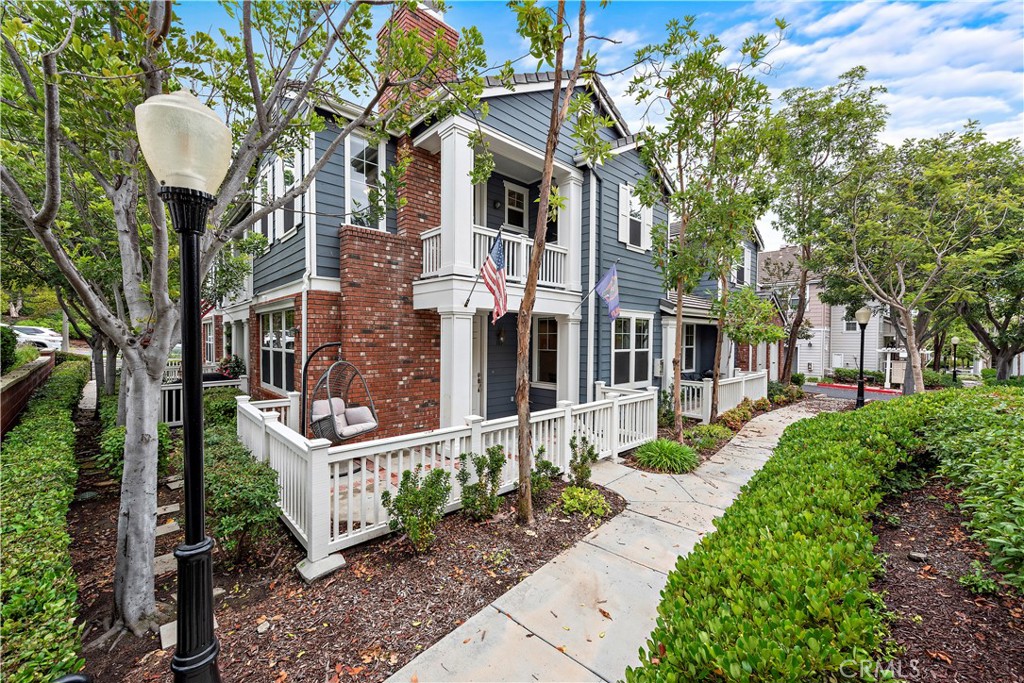 a front view of a house with a garden and trees