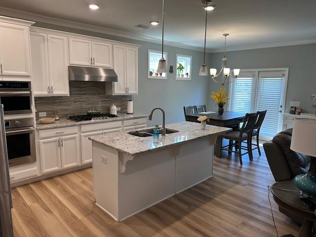 513 Forest Lane Canton, GA 30114 - Photo 23 of 54 a kitchen with stainless steel appliances granite countertop a stove a sink a microwave a dining table and chairs with wooden floor