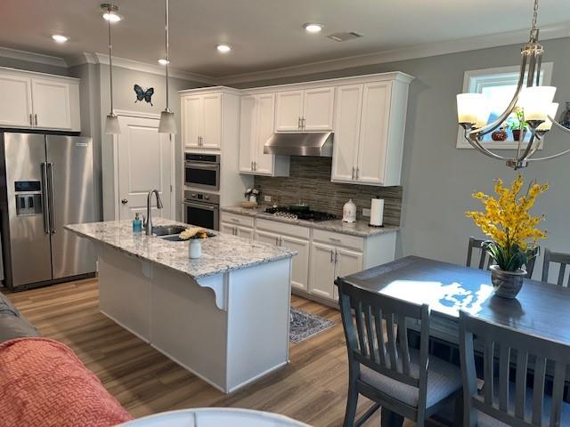 513 Forest Lane Canton, GA 30114 - Photo 26 of 54 a kitchen with stainless steel appliances granite countertop a table chairs sink refrigerator and microwave