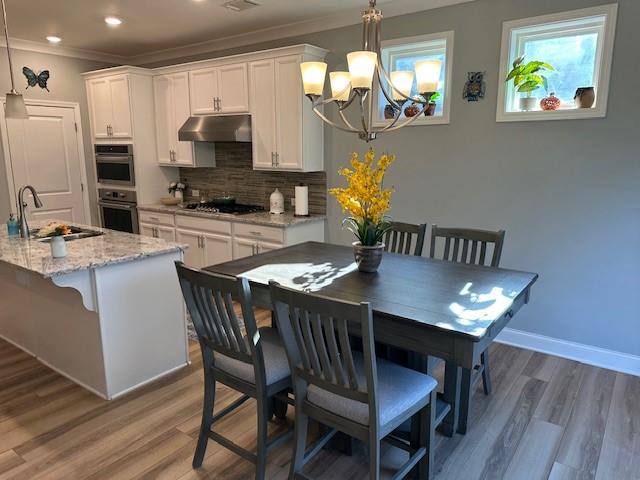 513 Forest Lane Canton, GA 30114 - Photo 27 of 54 a kitchen with stainless steel appliances granite countertop a dining table chairs and a refrigerator