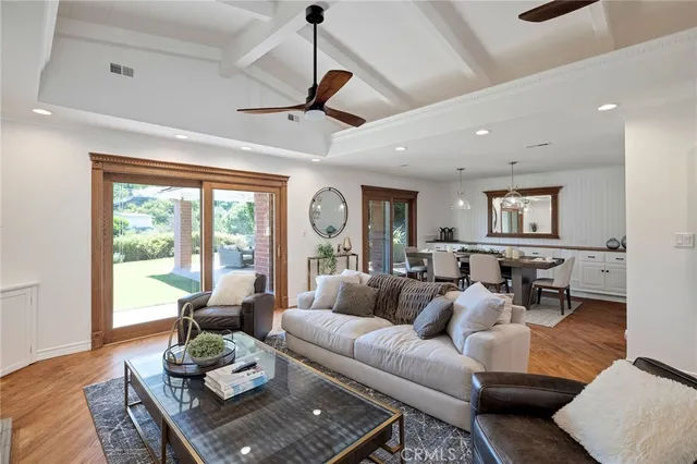 a kitchen with stainless steel appliances granite countertop a refrigerator a sink dishwasher a dining table and chairs with wooden floor