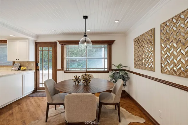 a hallway with white cabinets and wooden floor