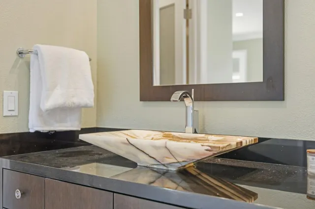 a bathroom with a granite countertop toilet sink and mirror