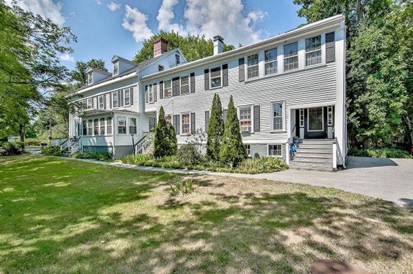 a front view of a house with a yard and potted plants