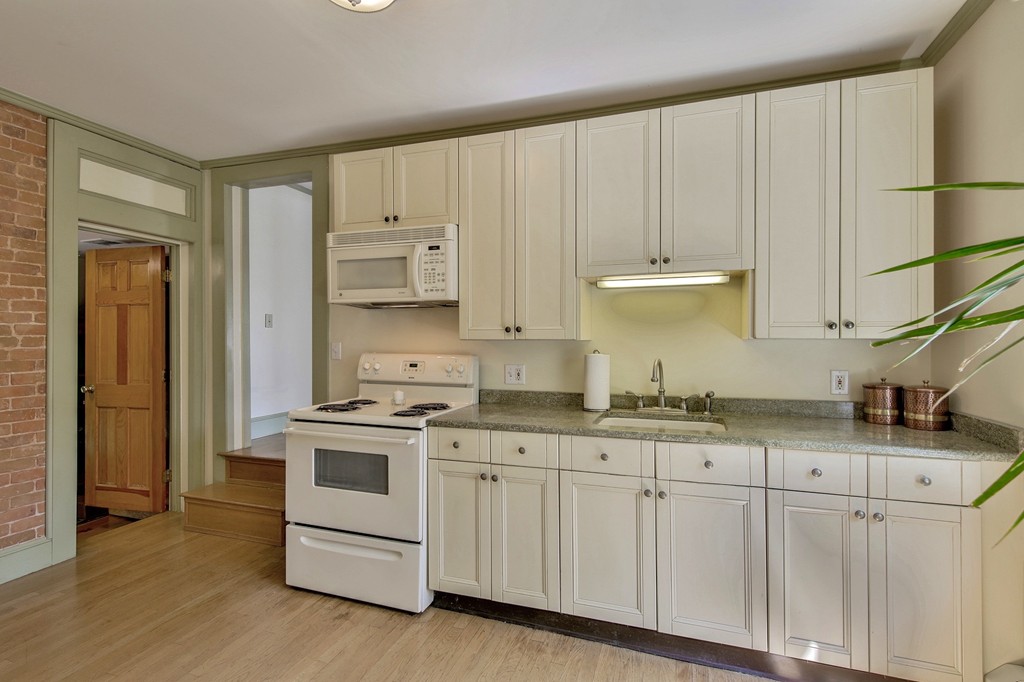 68 County Road, Unit C Ipswich, MA 01938 - Photo 4 of 13 a kitchen with granite countertop white cabinets and white appliances