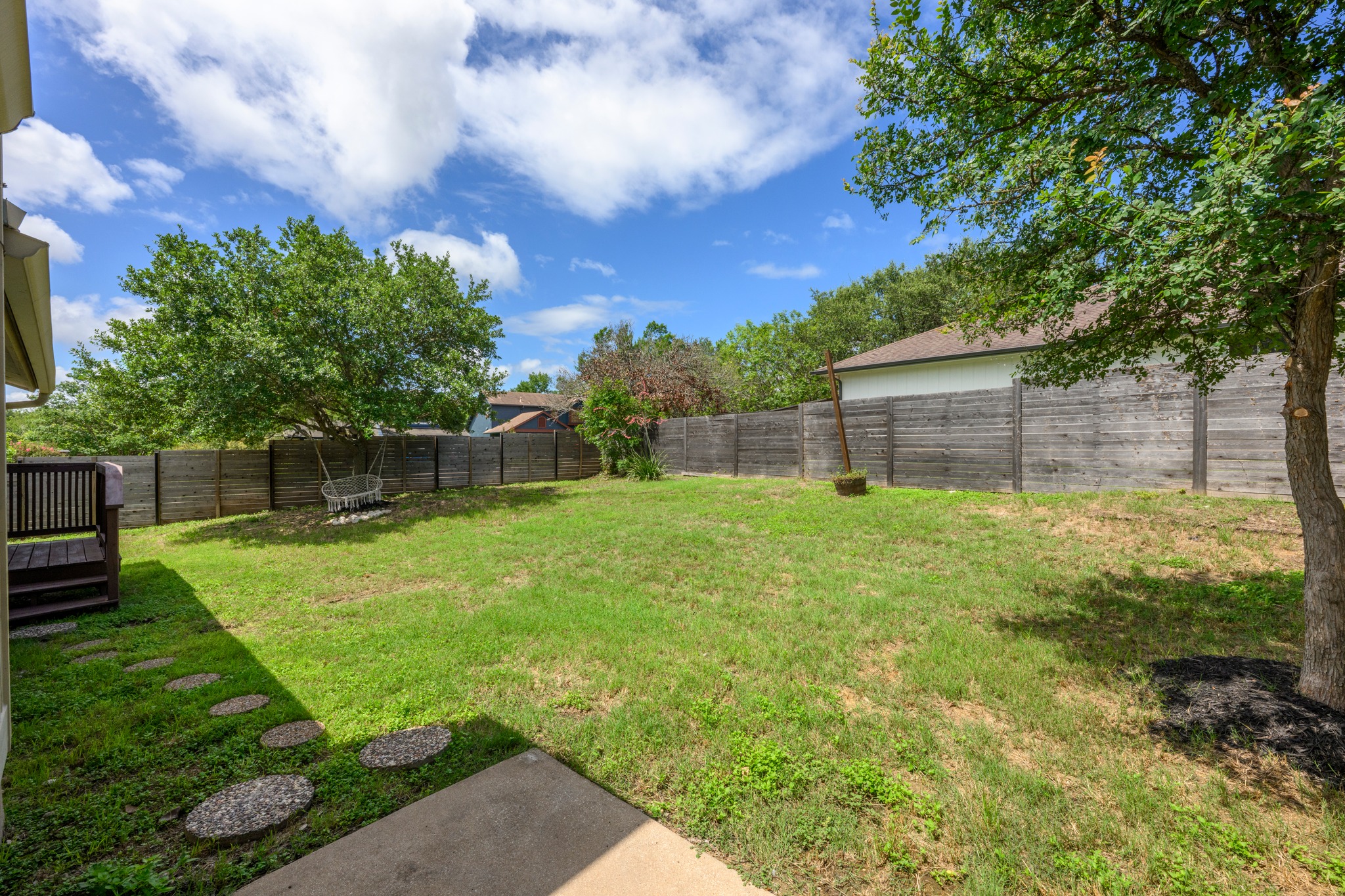 7210 Smokey Hill Road Austin, TX 78736 - Photo 24 of 29 A spacious backyard with mature trees provides ample green space for outdoor enjoyment and relaxation.