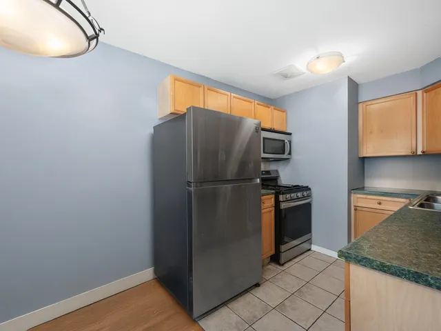 a kitchen with stainless steel appliances granite countertop a refrigerator and a stove