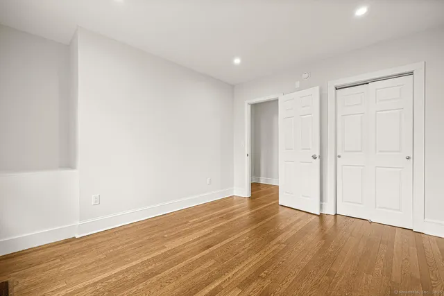 a view of an empty room with wooden floor