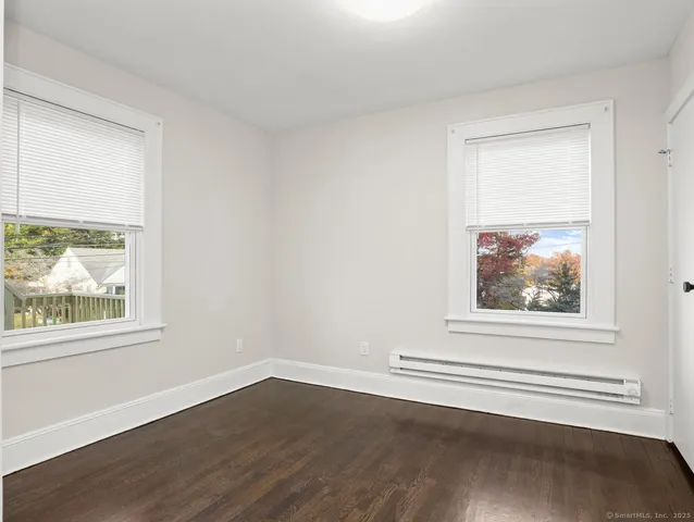 a view of a small space with wooden floor and a window