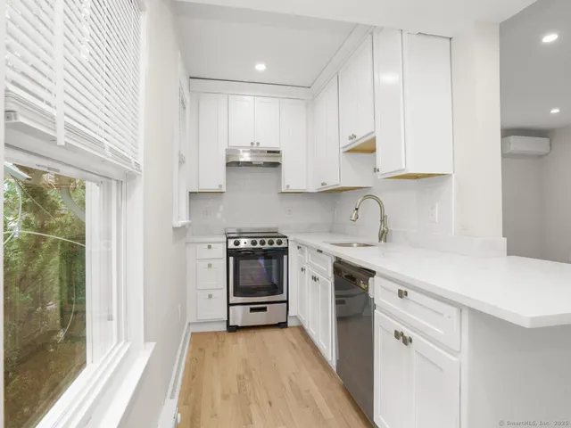 a kitchen with stainless steel appliances a sink stove and cabinets