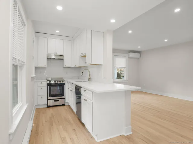 a kitchen with stainless steel appliances sink stove and cabinets