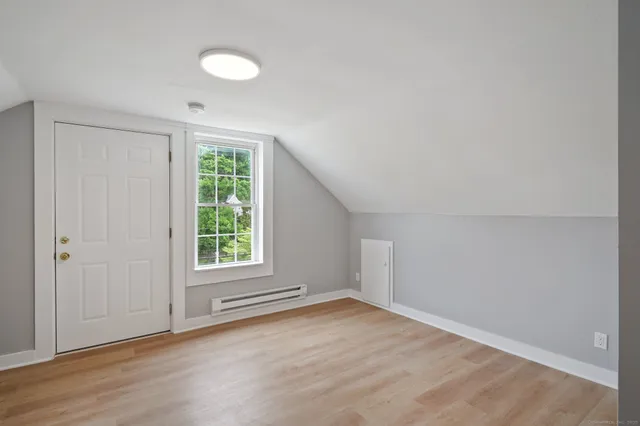 a view of a big room with wooden floor and windows