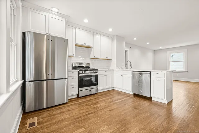 a kitchen with white cabinets and stainless steel appliances