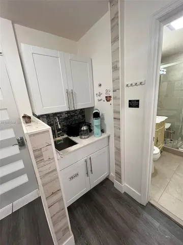 a kitchen with a refrigerator and white cabinets