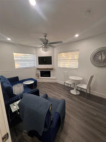 a living room with furniture wooden floor and a window
