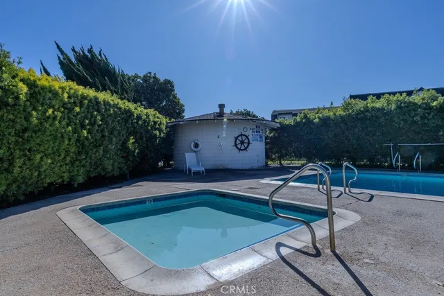 a view of a swimming pool with a patio and a yard