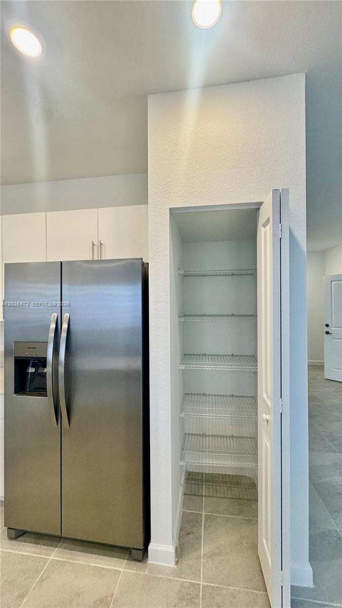 19479 Southwest 340th Street, Unit 1 Homestead, FL 33034 - Photo 37 of 58 a view of a refrigerator in kitchen and an empty room