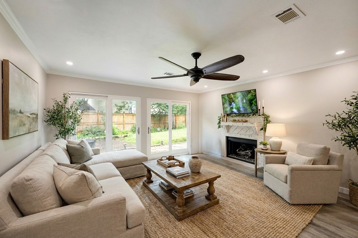 a living room with furniture a fireplace and a large window