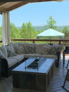 a roof deck with couches and umbrella