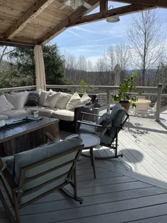 a view of a roof deck with table and chairs a barbeque with wooden floor and roof