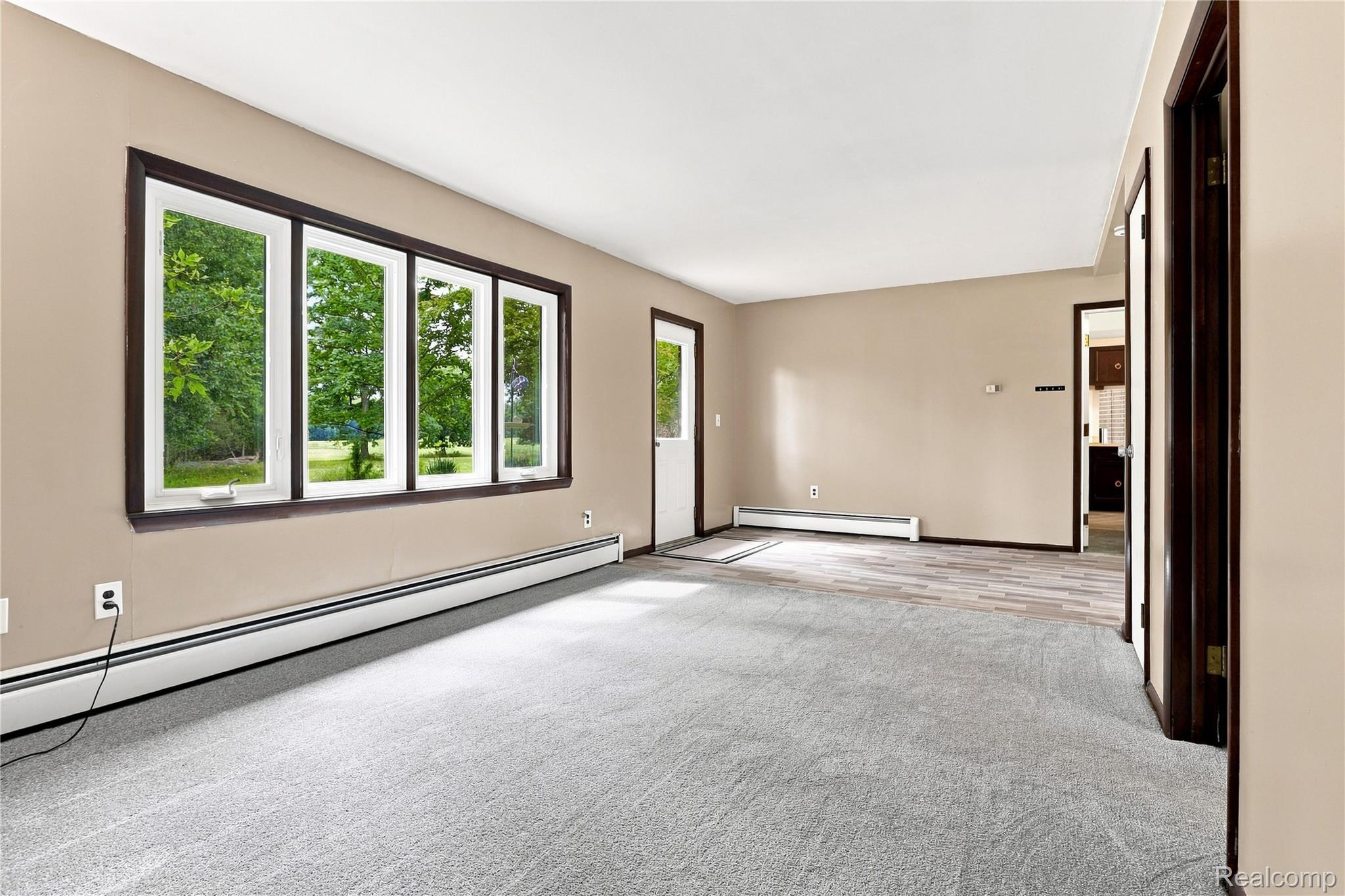 7386 Dean Road Fenton, MI 48430 - Photo 21 of 64 Expansive living area featuring light gray carpeting, wood-finish flooring, and neutral wall tones
