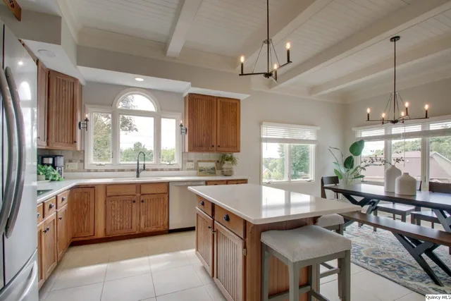 a large kitchen with kitchen island a large window a sink and living room view