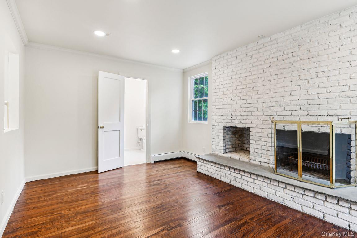 8 Mill Lot Road Middle Island, NY 11953 - Photo 10 of 20 an empty room with wooden floor and fireplace