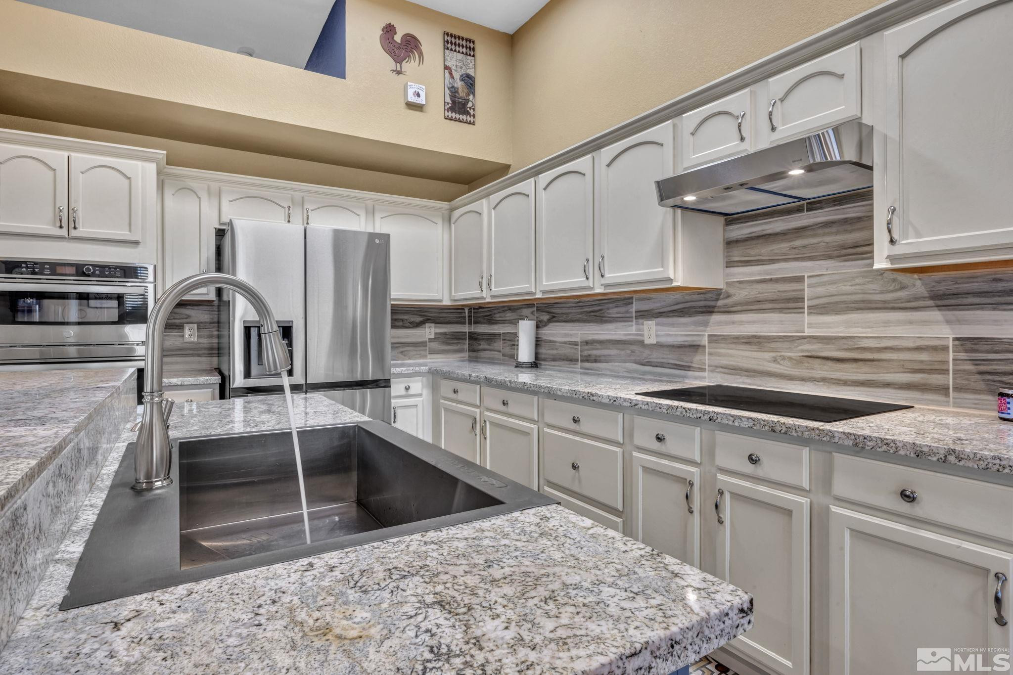 4805 Crestside Drive Sparks, NV 89436 - Photo 11 of 33 a kitchen with stainless steel appliances granite countertop a sink stove and cabinets