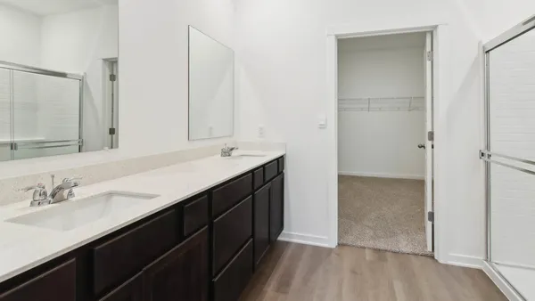 a bathroom with a double vanity sink a mirror and a shower