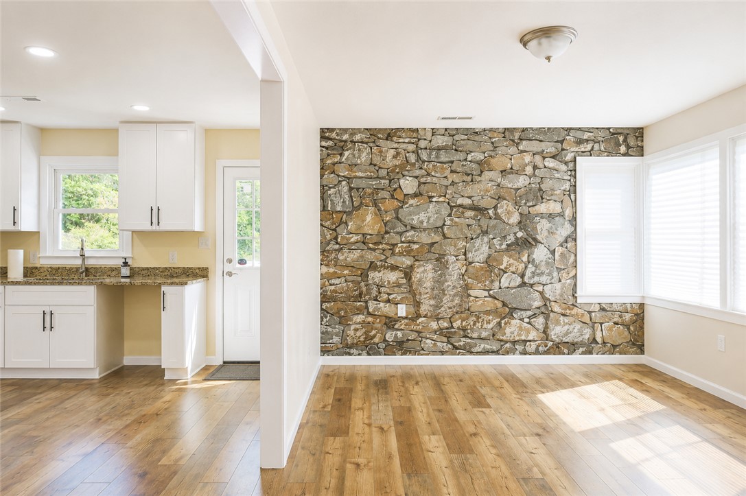 605 Hampton Street Iva, SC 29655 - Photo 5 of 16 A stone-accented wall adds rustic charm to this inviting interior space with rich hardwood flooring.