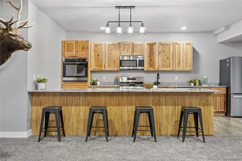 a kitchen with kitchen island granite countertop wooden floors and white appliances