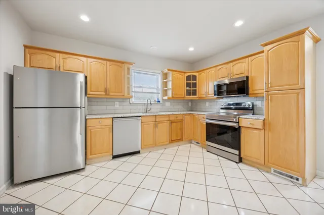 a kitchen with stainless steel appliances granite countertop a refrigerator sink and stove