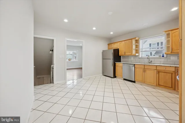 a kitchen with white cabinets a sink appliances and cabinets