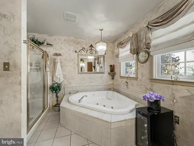 a bedroom with a bed dresser and a chandelier