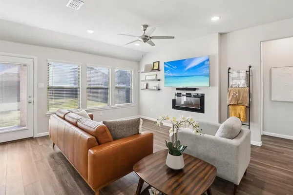 a living room with furniture kitchen view and a large window