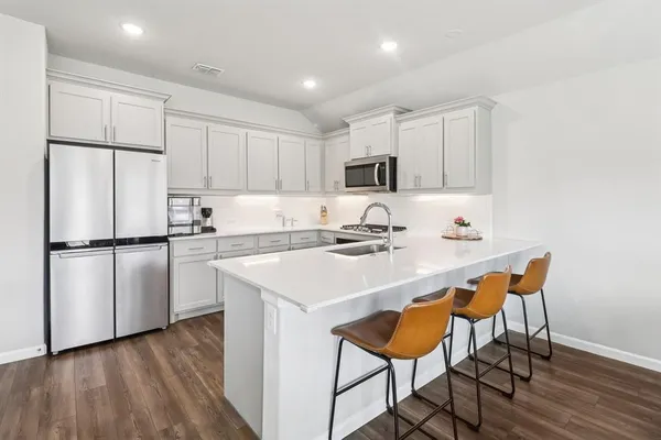a kitchen with stainless steel appliances a refrigerator and a stove top oven