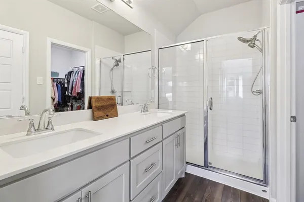 a bathroom with a double vanity sink mirror and shower
