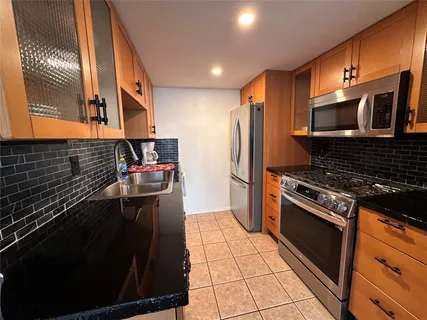 a kitchen with stainless steel appliances a stove a sink and a refrigerator